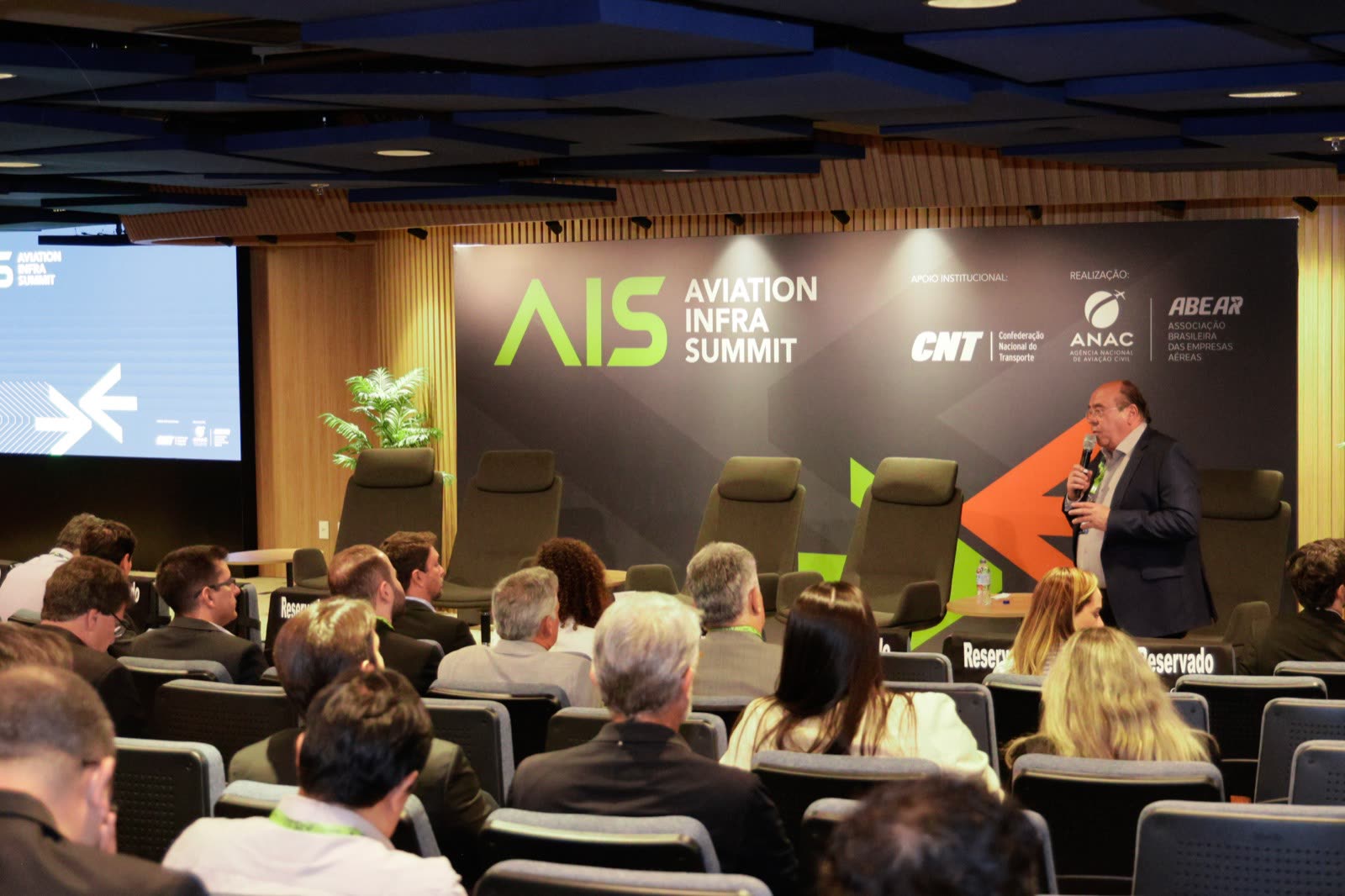 Plenária da 1ª edição do AIS — palco e plateia com a marca do evento
